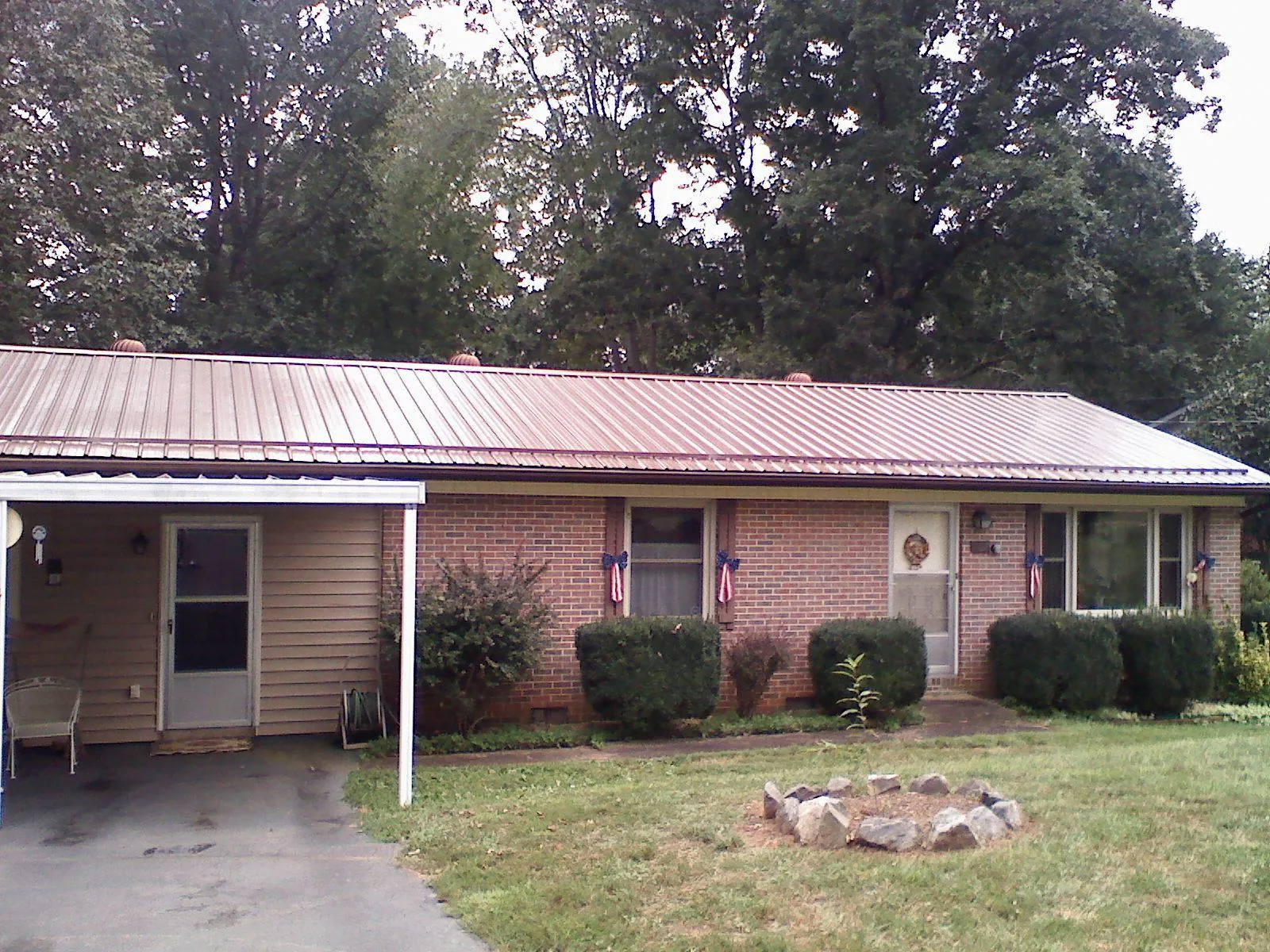 Bronze metal roof and carport on a brick ranch home — Roof Repair work by our crew in Shawnee